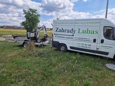 Dodávka Zahrady Lubas s přívěsem a minibagrem na pozemku